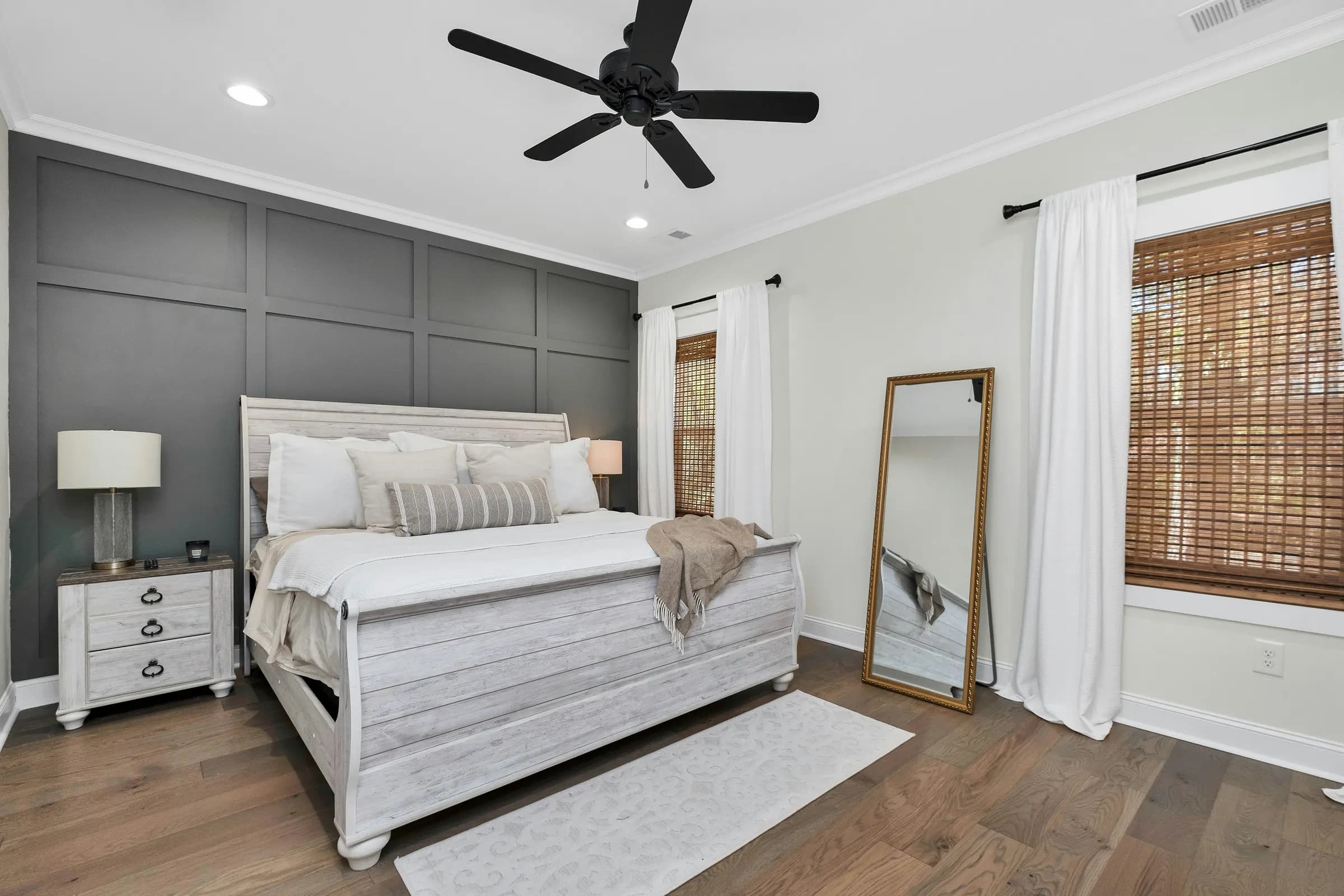 Bedroom with a dark charcoal board-and-batten accent wall behind a whitewashed bed