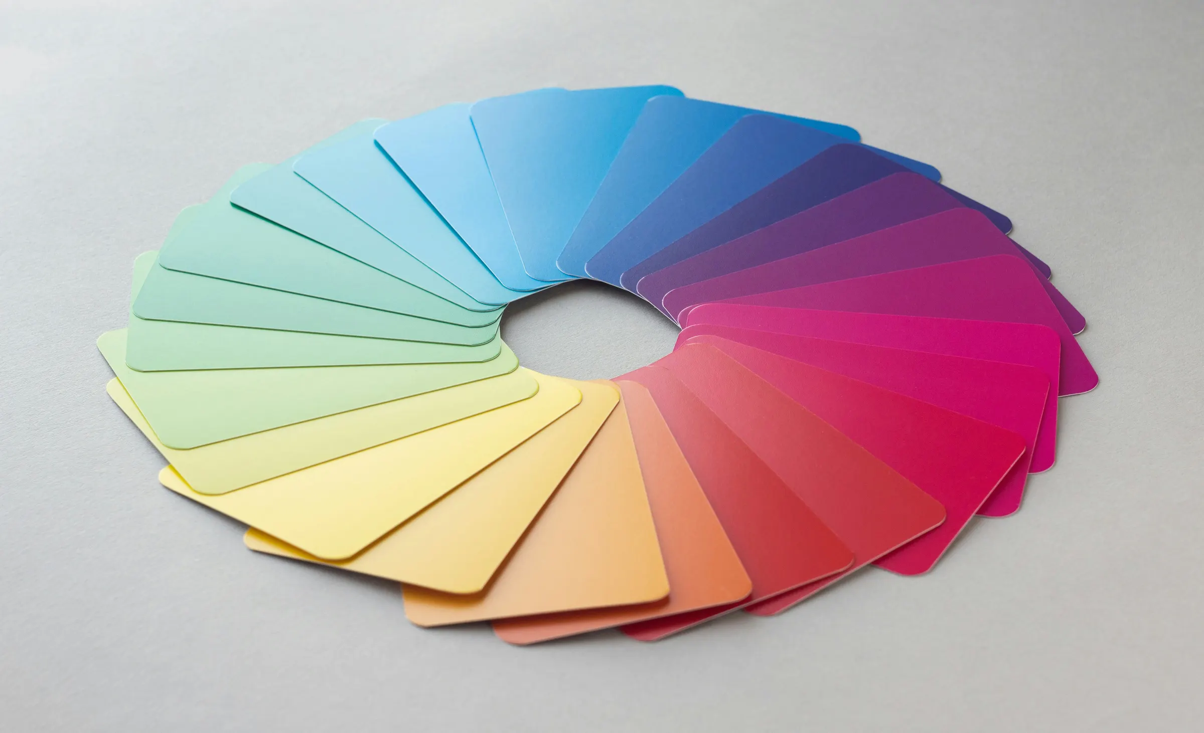 Paint color swatch cards fanned into a rainbow color wheel
